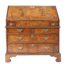 A George I Walnut Crossbanded and Featherbanded Bureau, early 18th century, the fall front enclosing