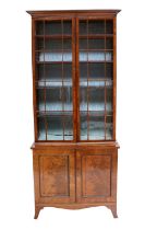 A Regency Mahogany, Tulipwood-Banded and Ebony-Inlaid Bookcase, early 19th century, the cavetto