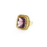 An Amethyst Ring, the rectangular cushion shaped amethyst in a yellow rubbed over setting, to a