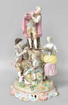 A Continental Porcelain Figure Group, 19th Century, a flautist stood on a rocky outcrop with a