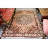 A West Iranian Rug, the salmon field centred by a floral medallion, with similar spandrals and