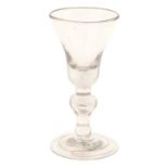 A Baluster Wine Glass, circa 1710, the bell-shaped bowl with basal air tear on an everted baluster