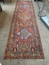 Narrow Heriz Runner, circa 1930 The brick red field with three large diamond medallions surrounded