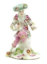 A Derby Porcelain Figure of a Boy, circa 1755, seated on a rock and holding three flowers in one