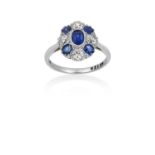 A Sapphire and Diamond Cluster Ring the oval cut sapphire in a white millegrain setting, within a