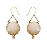A Pair of Moonstone and Pearl Drop Earrings the circular moonstone plaques carved to depict faces,