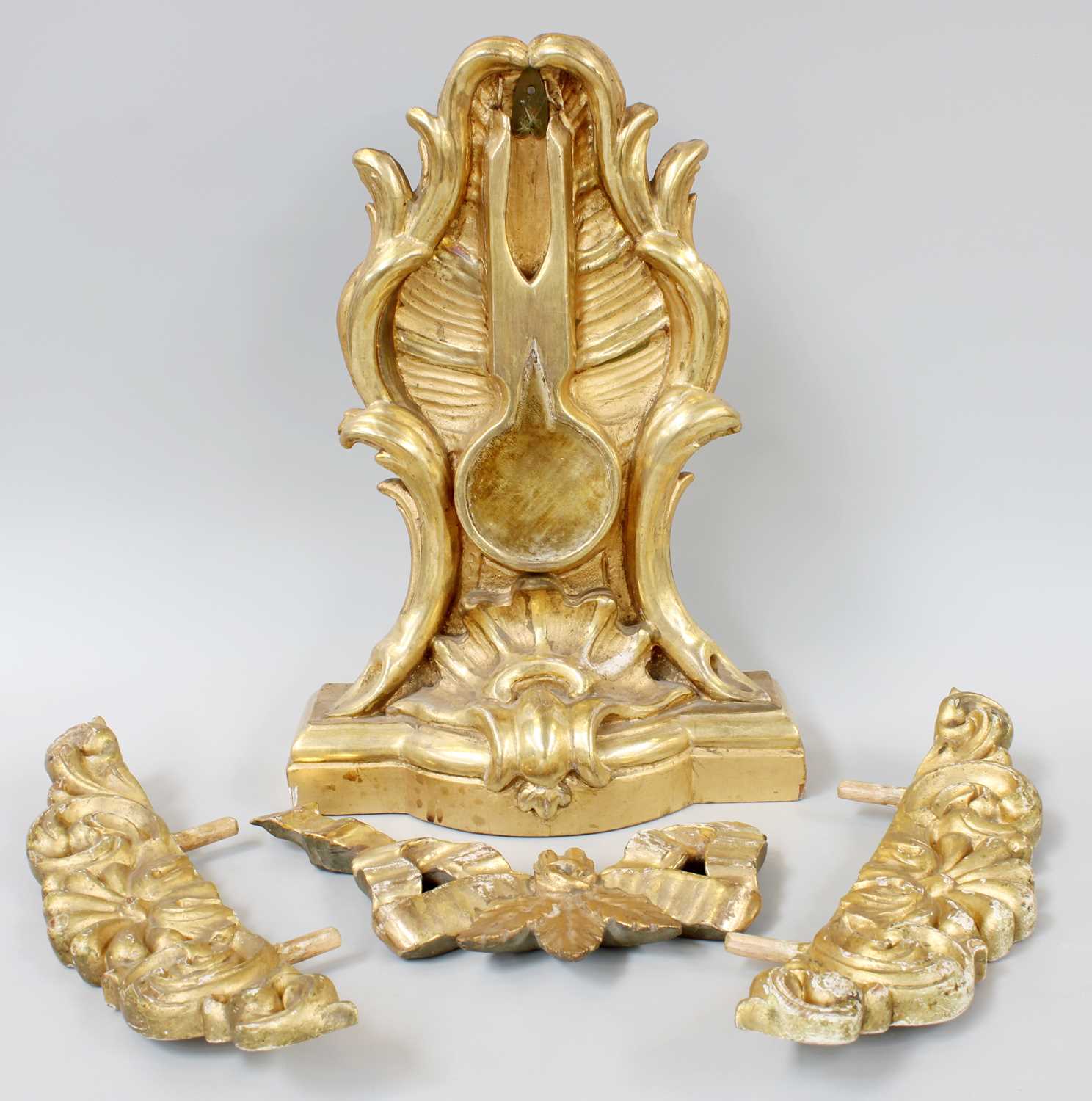 A Giltwood and Gesso Pocket Watch Stand, 19th century, ornamented with scrollwork and on bow front