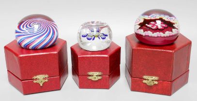 Three Limited Edition Perthshire Glass Paperweights, one with pink, white and blue swirl ground
