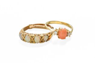 A 9 Carat Gold Coral and Diamond Three Stone Ring, the oval coral cabochon flanked by round