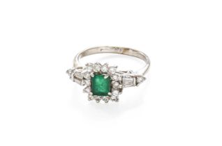 An Emerald and Diamond Cluster Ring, the rectangular step-cut emerald within a border of round
