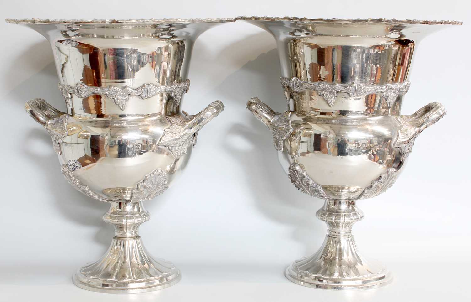 A Pair of Silver Plate Wine Coolers, baluster and on spreading foot, with fruiting grapevine stamped