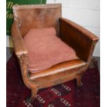 An Early 20th Century Tan Leather Tub Armchair, with brass studs and on scroll supports, 67cm by