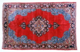 North West Persian Carpet Circa 1970 The crimson field with a central indigo anchor medallion framed