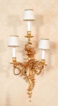 A Set of Nine Gilt Metal Three-Branch Wall Lights, in Louis XV style, the scroll cast sockets and