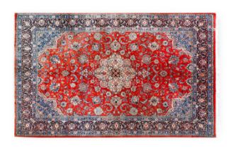 Central Iranian Carpet, circa 1960 The faded crimson field of scrolling vines and palmettes centered