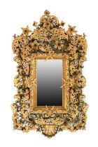 A Florentine-Style Carved Giltwood and Composition Mirror, the central bevelled glass mirror plate