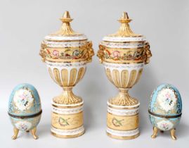 A Pair of Sèvres Style Porcelain Pedestal Urns and Covers, with gilt lion mask handles and painted
