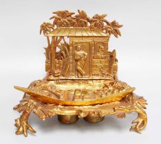 A Novelty Gilt Metal Desk Stand, formed as a riverside shack with a sailor and a native figure,