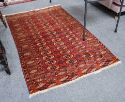 ~ A Tekke Rug, the brick red field with three columns of guls enclosed by borders of hooked