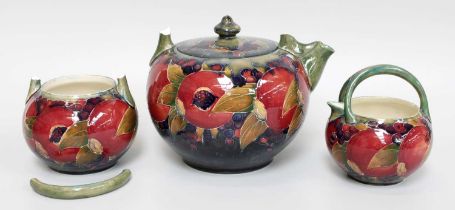 William Moorcroft (1872-1945): A Pomegranate Pattern Teaset, on a blue/green wash ground, green