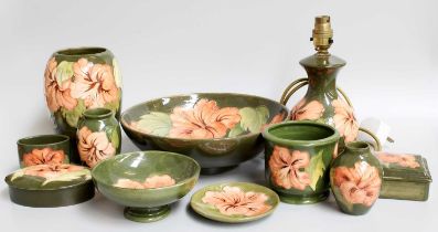 Walter Moorcroft Pottery, various shapes in the "Coral Hibiscus" design on green grounds, (11)