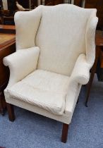 A George III Wing Back Armchair, in later cream coloured upholstery Some wear to the legs, a few