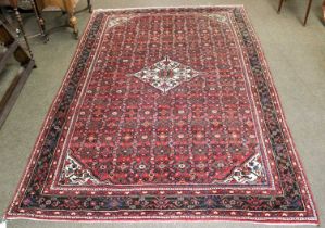 A Hosseinabad Carpet, the brick red field centered by an ivory diamond medallion framed by spandrels