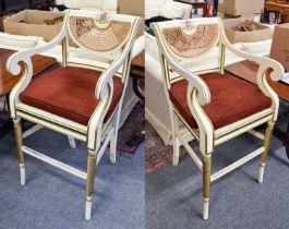 A Pair of Regency Style Cane Back Parcel Gilt Cream Painted Chairs, each crest rail painted with