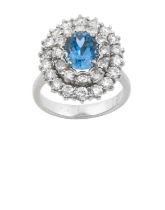 An Aquamarine and Diamond Cluster Ring the oval cut aquamarine within a double stepped border of