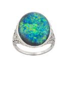 A Black Opal and Diamond Ring the oval black opal in a white rubbed over setting, to pierced