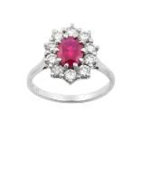 A Ruby and Diamond Cluster Ring the oval cut ruby within a border of round brilliant cut diamonds,