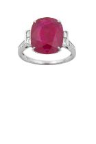 An 18 Carat White Gold Ruby and Diamond Ring the cushion cut ruby in a claw setting, flanked by