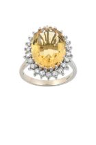 An 18 Carat White Gold Citrine and Diamond Cluster Ring the oval cut citrine within a border of