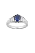 A Sapphire and Diamond Ring the oval cut sapphire in a white double claw setting, flanked by trios