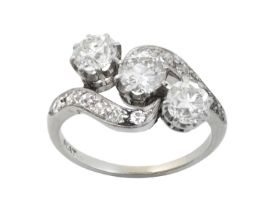 A Diamond Three Stone Twist Ring the central round brilliant cut diamond flanked by old cut