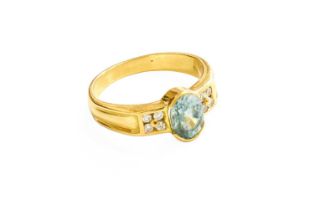 A Blue Zircon and Diamond Ring, the oval cut blue zircon flanked by round brilliant cut diamonds, in