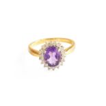 An 18 Carat Gold Amethyst and Diamond Cluster Ring, the oval cut amethyst within a border of round