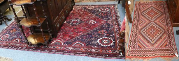 Kashgai Carpet, the raspberry field of tribal motifs and birds centered by an indigo stepped