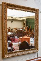 A Gilt Framed Mirror, the rectangular bevelled plate within a conforming frame, 89cm by 101cm