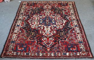 Bakhtiar Rug, the midnight blue field of angular vines centered by a large ivory medallion, framed