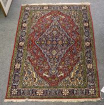 Ghom Rug, the terracotta field with an indigo medallion framed by spandrels and floral borders,