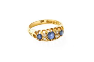 An 18 Carat Gold Sapphire and Diamond Ring, three oval cut sapphires, spaced by pairs of old cut