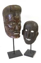 A Lagoon Type Mask, Ivory Coast, the oval face covered in a dark pigment, with pierced oval eyes,