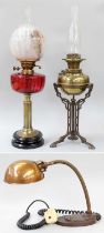 A Victorian Brass Based Oil Lamp, with cranberry glass reservoir, together with a similar Arts &