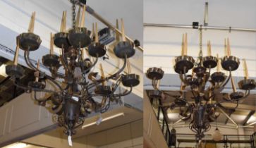 A Pair of Impressive Brown Patinated Twelve-Branch Chandeliers, early 20th century, with scrolled