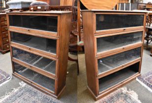 A Pair of 1930s Oak Four Tier Sectional Bookcases, 94cm by 29cm by 116cm One bookcase with a missing