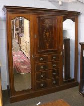 An Edwardian Mahogany Wardrobe, the central section as a cupboard with two shelves, over four