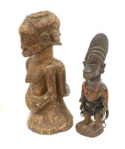 A Yoruba Carved Wood Ibiji, standing with high combed coiffure, wearing a coral necklace and brown
