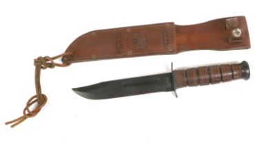 A US MC Ka-Bar Knife, the 17.5cm clip-point blackened steel blade stamped USMC to one side of the