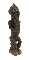 An Early 20th Century Baule Figure of a Man, Ivory Coast, of dark brown mellow patina, seated